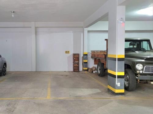 a parking garage with a truck parked in it at Casa - Centro Px Matriz c/ Churrasqueira, 2 Suítes in Poços de Caldas