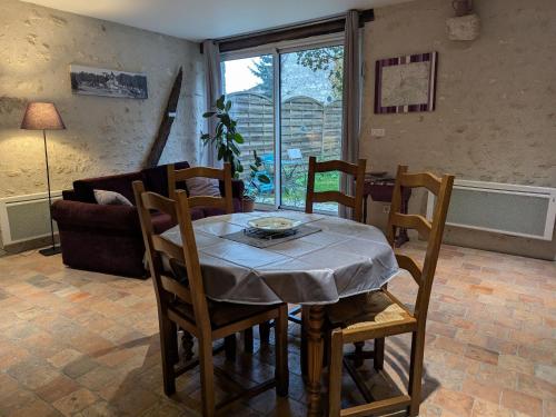 une salle à manger avec une table, des chaises et un canapé dans l'établissement Charmante maison près des châteaux de la Loire avec jardin fermé et animaux bienvenus - FR-1-590-65, à Saint-Hilaire-Saint-Mesmin