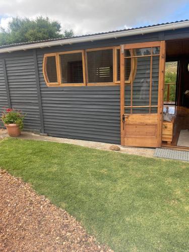 a house with a wooden door and a yard at The Country Cabin in Caledon