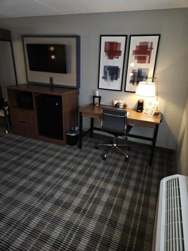 a hotel room with a desk and a television at AmericInn by Wyndham Mounds View Minneapolis in Mounds View