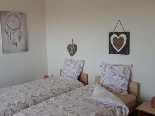 - une chambre avec un lit et un cœur suspendu au mur dans l'établissement Location paisible: gîte familial avec balnéo, cuisine équipée et départs VTT, à proximité de Gérardmer - FR-1-589-331, à Frémifontaine
