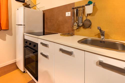 a kitchen with a white refrigerator and a sink at Camping Camplani in Zone