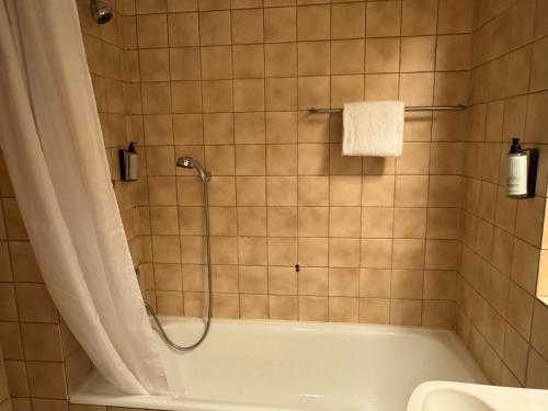 a bathroom with a bath tub with a shower at Park Hotel Vossevangen in Vossevangen