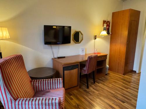 a hotel room with a desk and a tv at Park Hotel Vossevangen in Vossevangen