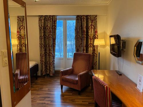 a room with a table and a chair and a window at Park Hotel Vossevangen in Vossevangen