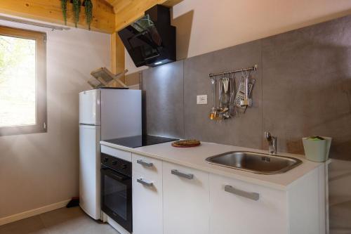 a kitchen with a sink and a refrigerator at Camping Camplani in Zone