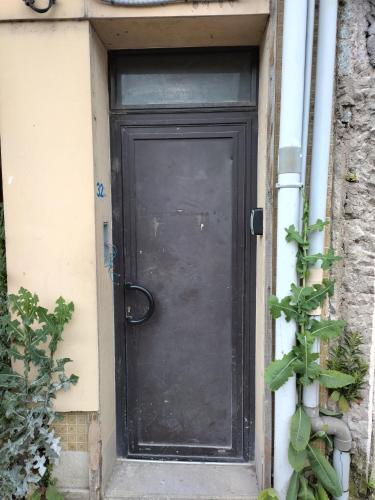 une porte noire sur le côté d'une maison dans l'établissement Studio 2 proche de la gare SNCF, à Angoulême