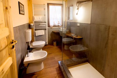 a bathroom with three toilets and a sink at Camping Camplani in Zone