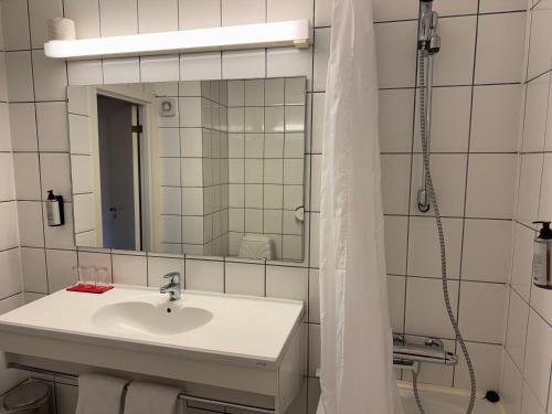 a white bathroom with a sink and a mirror at Park Hotel Vossevangen in Vossevangen