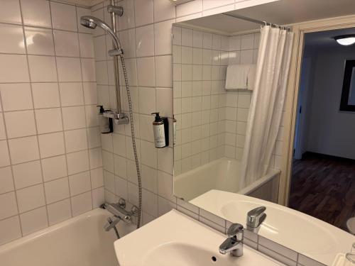a bathroom with a sink and a tub and a shower at Park Hotel Vossevangen in Vossevangen