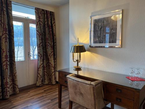 a room with a desk with a lamp and a chair at Park Hotel Vossevangen in Vossevangen