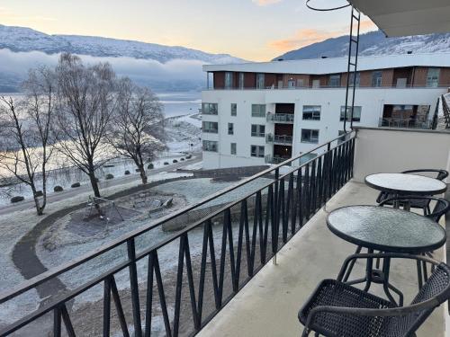 a balcony with tables and chairs on a building at Park Hotel Vossevangen in Vossevangen