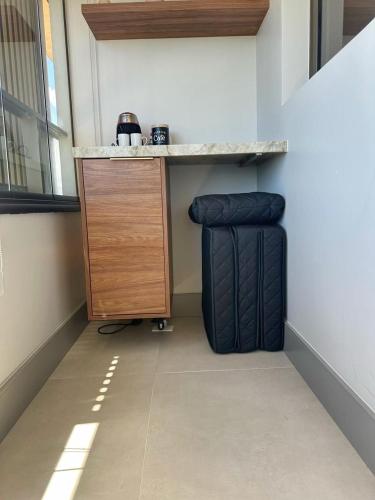 a room with a counter and a table and a suitcase at New Studios by VLV Stays in Salvador