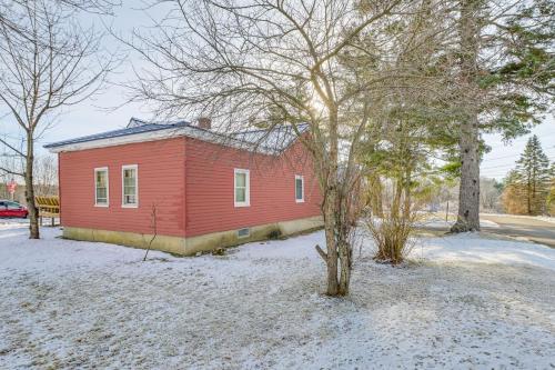 a red house with a tree in the snow at Close to Dtwn Bangor Inviting Maine Home in Veazie