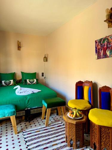 a room with a bed and two chairs and a table at Riad Hamad Tijani in Fès