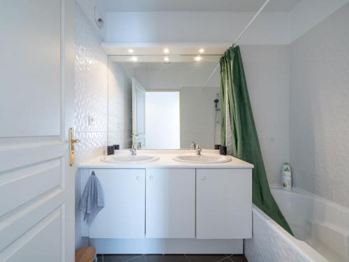 une salle de bain blanche avec deux lavabos et un miroir dans l'établissement L'Arlequin Familial et Reposant, à Villeurbanne