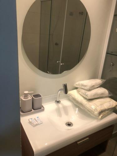 a bathroom with a sink with a mirror and towels at Rua Dr Diogo de Faria 671 Apto 13 in Sao Paulo