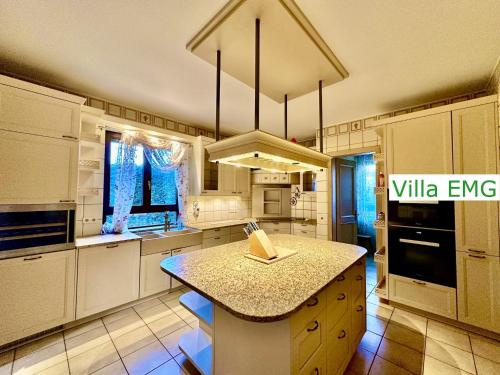 a kitchen with white cabinets and a island in it at Luxury Spa Villa EMG Karlsruhe Baden-Baden Rastatt - Gernsbach in Gernsbach