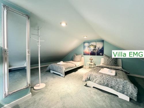a attic bedroom with two beds and a window at Luxury Spa Villa EMG Karlsruhe Baden-Baden Rastatt - Gernsbach in Gernsbach