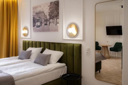 a bedroom with a bed with a green headboard at Stara Drukarnia Aparthotel in Koszalin
