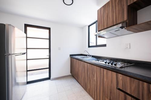 a kitchen with a sink and a refrigerator at Residencias Viterbo in Casa Blanca La Corregidora