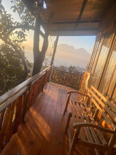 a wooden deck with a bench and a tree at La casa abue in San Pablo La Laguna