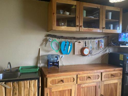 a kitchen with wooden cabinets and utensils on the wall at La casa abue in San Pablo La Laguna