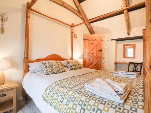 a bedroom with a large bed with a wooden frame at Bwthyn Alarch in Haverfordwest
