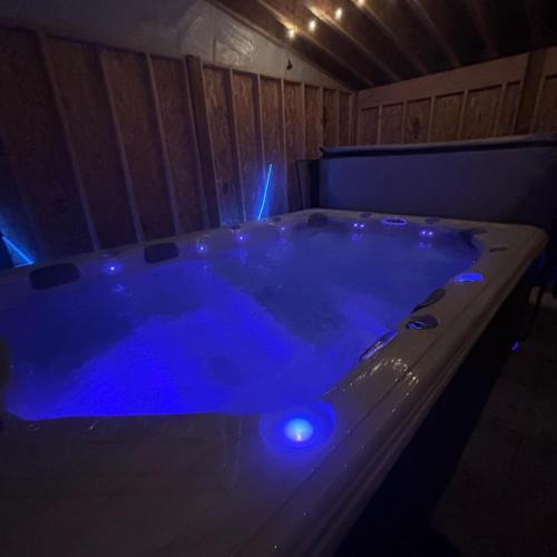 a jacuzzi tub with blue lights in a room at Les Suites des Chutes - La Royale in Boischâtel