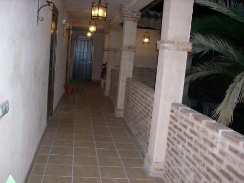 a hallway of a house with a tile floor and columns at La Venta del Arriero in Retuerta de Bullaque