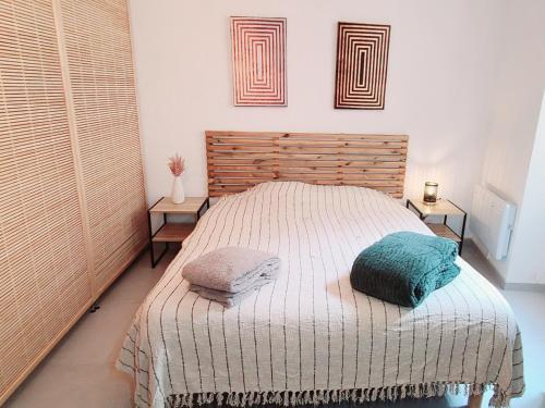 une chambre avec un lit avec deux oreillers dessus dans l'établissement Le Marceau Cour Extérieure, à Narbonne