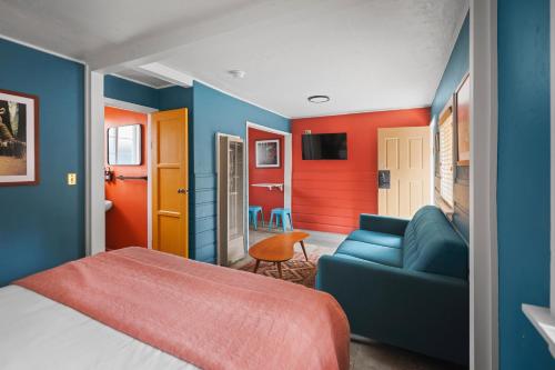 a bedroom with a bed and a blue couch at Sessions Retreat & Hotel in Big Bear Lake