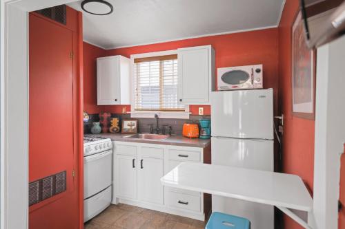 a kitchen with red walls and a white refrigerator at Sessions Retreat & Hotel in Big Bear Lake
