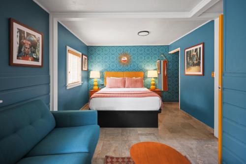 a blue bedroom with a bed and a couch at Sessions Retreat & Hotel in Big Bear Lake