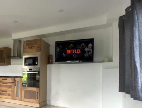 a kitchen with a tv on top of a wall at Spring Valley Vista, Ocean View Apartment Ocho Rios in Tower Isle