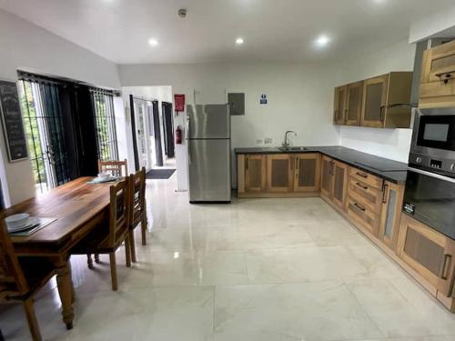 a kitchen with a wooden table and a kitchen with a refrigerator at Spring Valley Vista, Ocean View Apartment Ocho Rios in Tower Isle