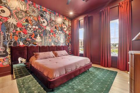 a bedroom with a bed and a wall with a mural at Circo Loco in Louisville
