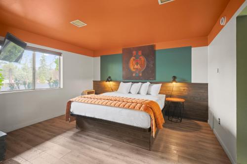 a bedroom with a large bed with an orange ceiling at Sessions Retreat & Hotel in Big Bear Lake
