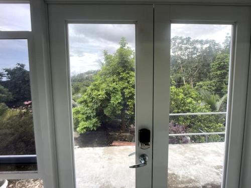 an open door with a view of a yard at Spring Valley Vista, Ocean View Apartment Ocho Rios in Tower Isle