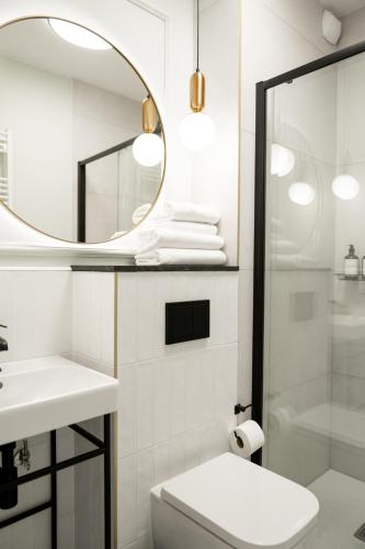a bathroom with a sink and a mirror at Stara Drukarnia Aparthotel in Koszalin