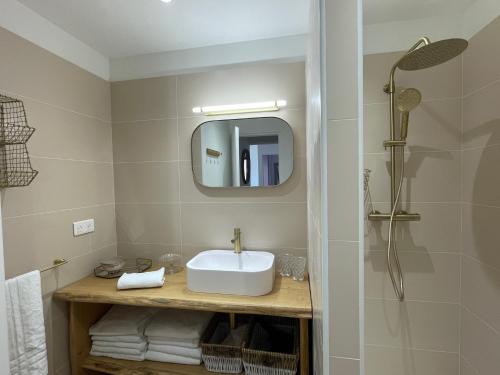 une salle de bain avec un lavabo et un miroir dans l'établissement Appartement Marinella route des Sanguinaires Corse, à Ajaccio