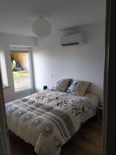 une chambre blanche avec un lit avec une fenêtre dans l'établissement Meublé Climatisé 75 M2, à Souvans