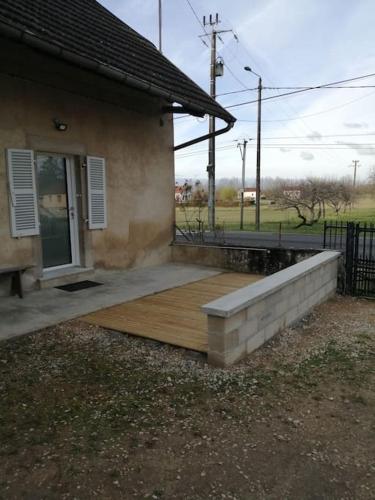 une terrasse couverte d'une maison avec une terrasse en bois dans l'établissement Meublé Climatisé 75 M2, à Souvans