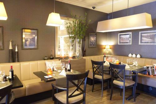 a restaurant with tables and chairs and a couch at Hotel The New Fox in Affligem
