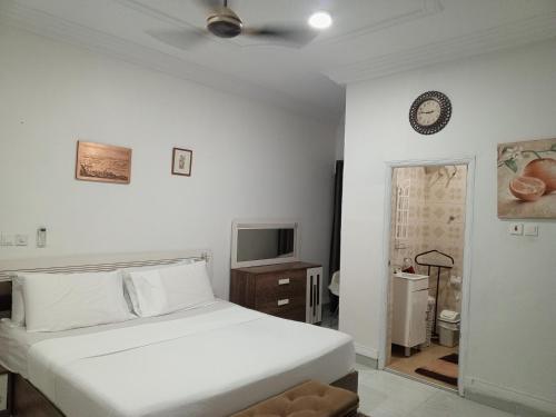 a white bedroom with a bed and a tv at Holiday Home in Takoradi