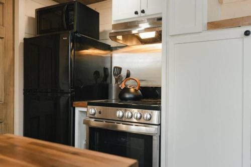 a kitchen with a stove with a tea kettle on it at Thistle House at Camp Greenwood Vermont with Sauna in Chester