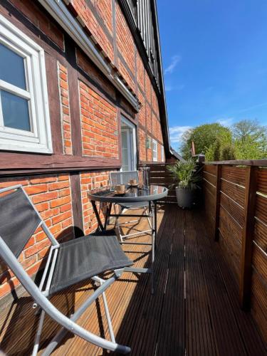 a patio with a table and a chair on a deck at Pauerhof Ferienwohnungen in Bad Nenndorf
