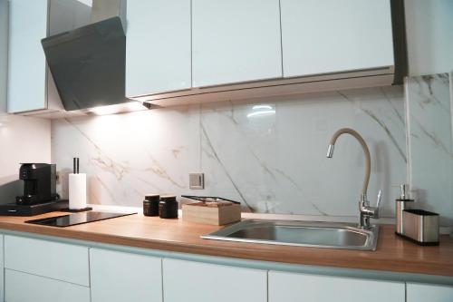 a kitchen with white cabinets and a sink at Riverside in Florina