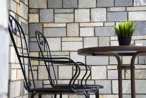 two chairs and a table in front of a brick wall at Riverside in Florina