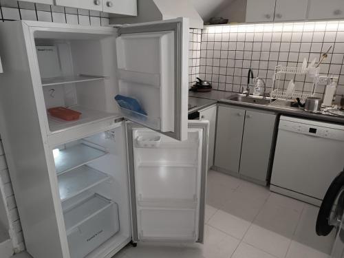 a kitchen with an open refrigerator with its door open at Sea view Beach House with Pool in Limassol